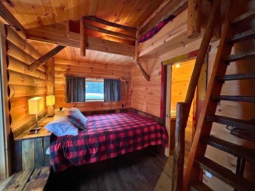 拉马巴耶HUSKY - Chalets de Môh - Jacuzzi的小木屋内一间卧室,配有一张床