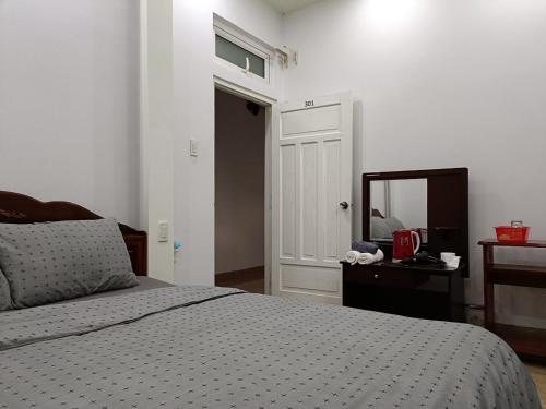 大叻Grey House的一间卧室配有一张床、镜子和门