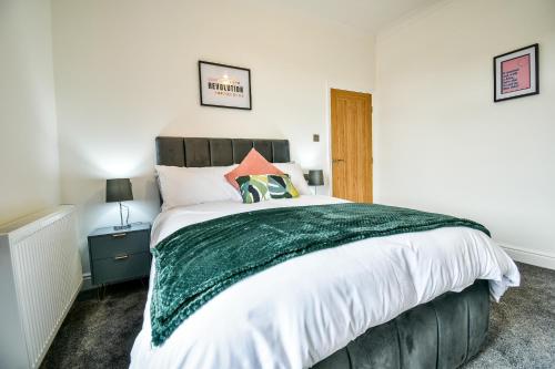 蒂斯河畔斯托克顿Benson house By Horizon Stays的一间卧室配有一张带绿毯的大床