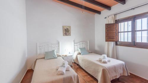 林孔-德拉维多利亚Casa Elena de Benagalbon Rincon de la Victoria by Ruralidays的一间设有两张床铺和毛巾的房间