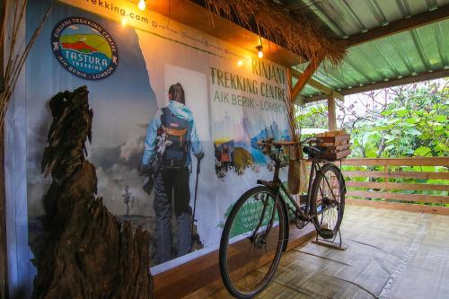 普拉亚Tastura Homestay的一辆自行车停在墙上,墙上挂着海报