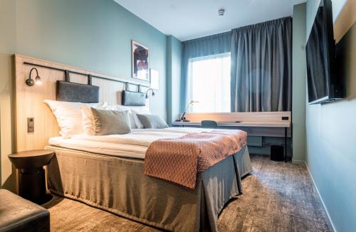 布罗斯布罗斯格兰德品质酒店的一间卧室配有一张带书桌的床和窗户。