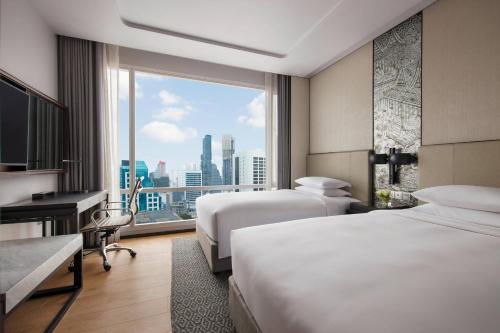 曼谷曼谷苏拉旺万豪酒店的酒店客房设有两张床和窗户。