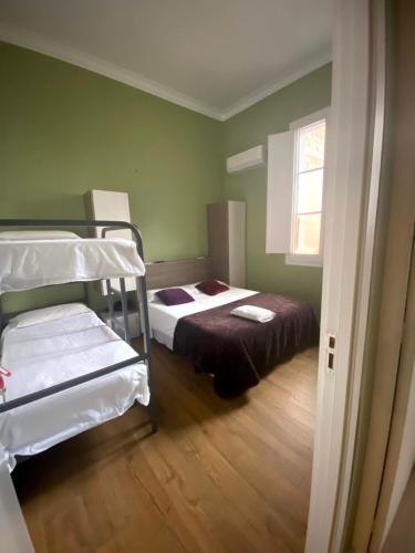 巴塞罗那SANT ANTONI HOSTAL, Sustainable Tourism的一间卧室设有两张双层床和一扇窗户。