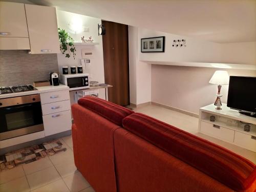 拉奎拉Come a casa的客厅设有红色沙发,位于厨房内