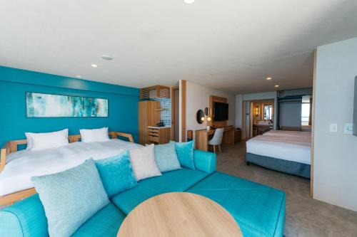 恩纳AQUASENSE Hotel & Resort的一间卧室配有一张大床和一张沙发