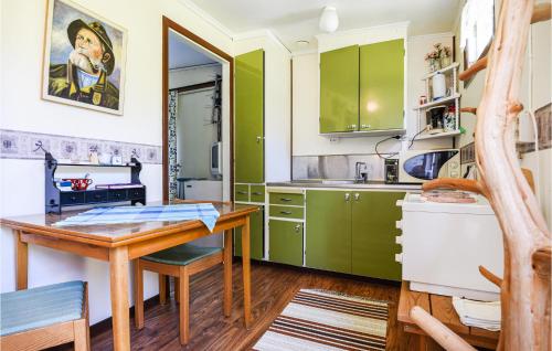 Slite2 Bedroom Lovely Home In Slite的厨房配有绿色橱柜和木桌