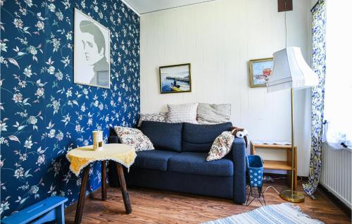 Slite2 Bedroom Lovely Home In Slite的客厅配有蓝色的沙发以及蓝色和白色的壁纸