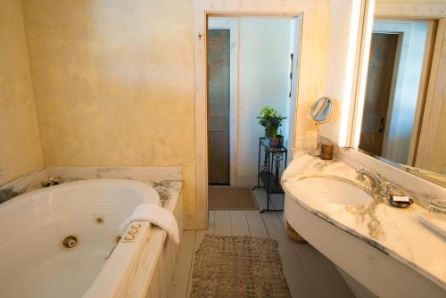 New Marlborough格林老客栈宾馆的带浴缸、水槽和镜子的浴室