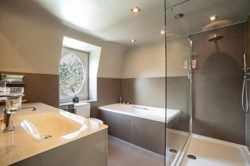滑铁卢Waterloo Garden residence的带淋浴、盥洗盆和浴缸的浴室