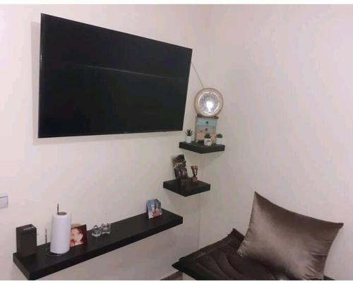 卡萨布兰卡Apartment bien equipee acasa的挂在墙上的平面电视,配有沙发
