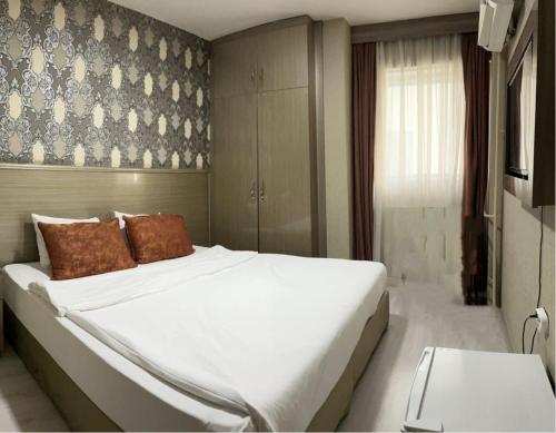 伊兹密尔Metro Otel的卧室配有带棕色枕头的大型白色床