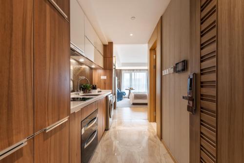 广州广州丽途国际公寓酒店（金融城店）的厨房设有木制橱柜和长长的走廊