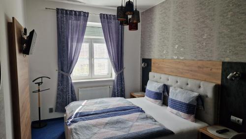 索科洛夫Penzion PIANO & Apartment Sokolov的一间卧室配有一张带紫色窗帘的床和窗户。