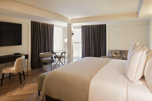 莱塞斯卡尔德-恩戈尔达Hotel MIM Andorra的配有一张床和一张书桌的酒店客房