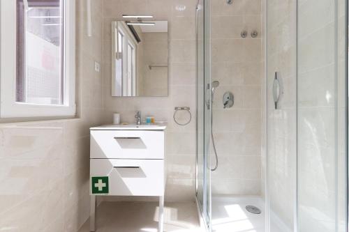 辛特拉Sintra Flower Lux Apartments的带淋浴和盥洗盆的白色浴室