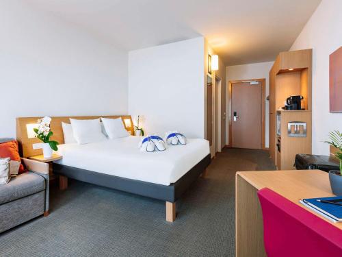 梅斯特诺富特威尼斯梅斯特卡斯特拉纳酒店的酒店客房设有一张大床和一张沙发。
