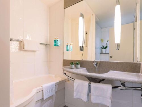 梅斯特诺富特威尼斯梅斯特卡斯特拉纳酒店的一间带水槽、浴缸和镜子的浴室