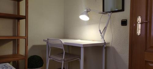 马德里Habitacion individual en apartamento céntrico的客房配有桌椅和台灯