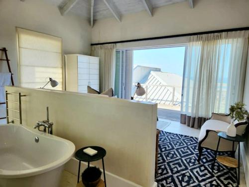 普利登堡湾Contemporary villa with amazing views的一间带白色浴缸和大窗户的浴室