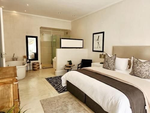 普利登堡湾Contemporary villa with amazing views的一间卧室设有一张大床和一个浴缸