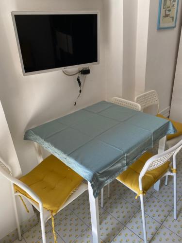 罗马Apartment Metro Tor Di Valle的一张桌子、椅子和墙上的电视