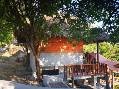 涛岛Koh Tao Relax Freedom Beach Resort的一座小楼,有树和长凳