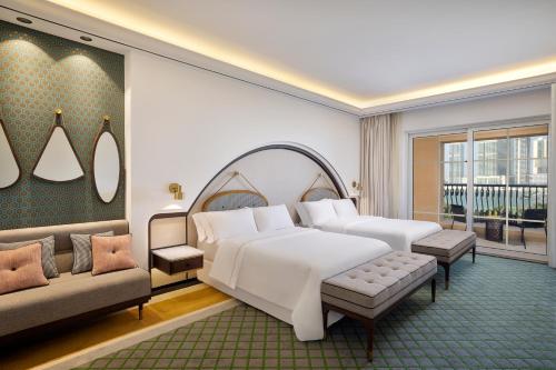 迪拜The Westin Dubai Mina Seyahi Beach Resort and Waterpark的一间卧室配有一张大床和一张沙发