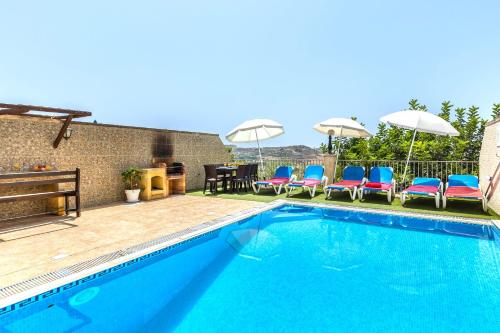 马萨尔福恩Ta Guljetta 4 bedroom Villa with private pool的游泳池配有椅子、桌子和遮阳伞
