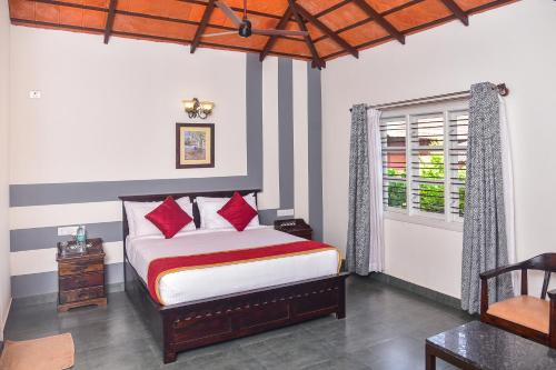 马迪凯里Clover Holiday Village的一间卧室配有一张带红色枕头的床和一扇窗户