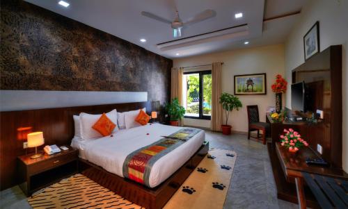 萨瓦伊马多普尔Spree Jungle Vilas Resort Ranthambore的一间卧室配有一张特大号床和一张书桌