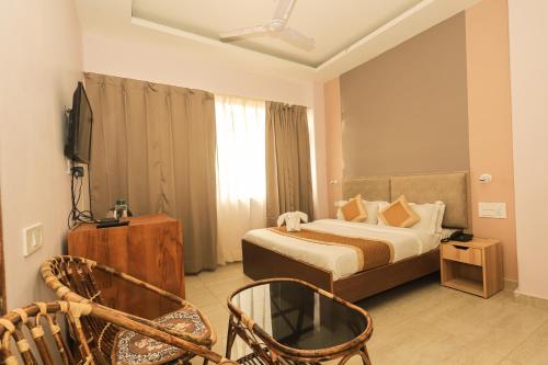 达兰萨拉Hotel Buddha's Abode的酒店客房,配有一张床和两把椅子