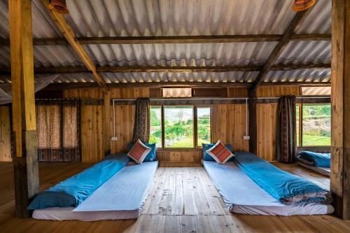 萨帕River mountain view homestay的木屋内的一个房间,配有三张床
