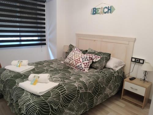 希洪Apartamento GIJON LOS CAMPOS的一间卧室配有一张床,上面有两条毛巾