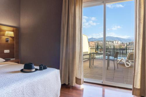 格拉纳达Hotel Macià Monasterio de los Basilios的一间卧室设有一张床和一个美景阳台