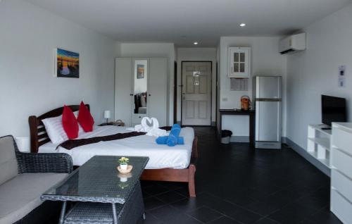 卡马拉海滩Deng's kamala beach Guesthouse的客房设有两张床、一张沙发和一张桌子。