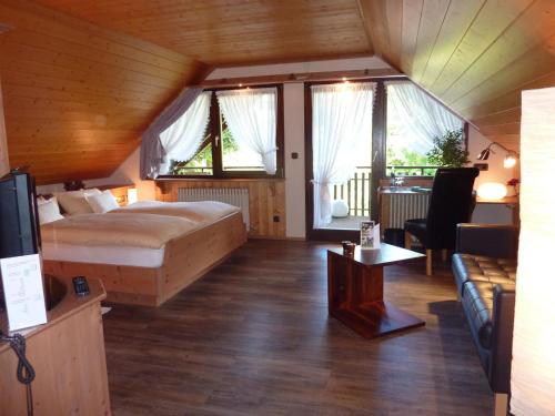 盖斯巴赫穆尔格巴赫兰德酒店的一间卧室设有一张床和一间客厅。