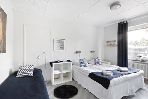 锡姆里斯港奥罗拉住宿加早餐酒店的一间白色卧室,配有两张床和窗户