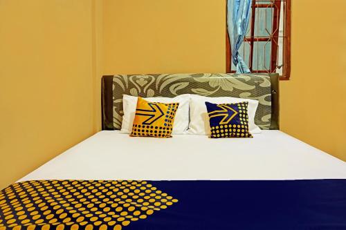 玛琅SPOT ON 92450 Homestay Simpang Panji Suroso Syariah的一张床上有四个枕头的房间