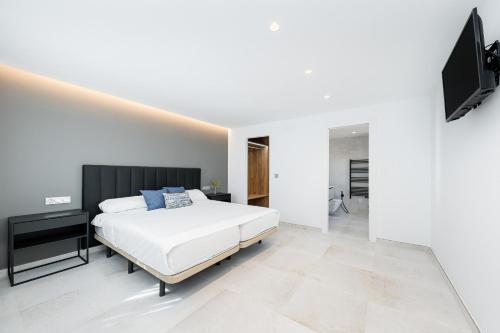 托雷维耶哈Sunrise Center Suites的白色卧室配有床和平面电视