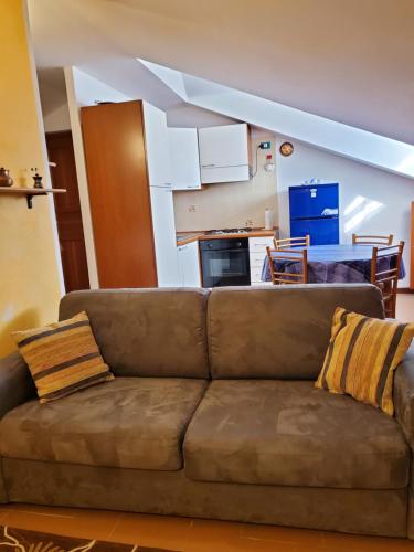 圣文森特Mansarda Via Chanoux的客厅设有一张棕色沙发,配有厨房