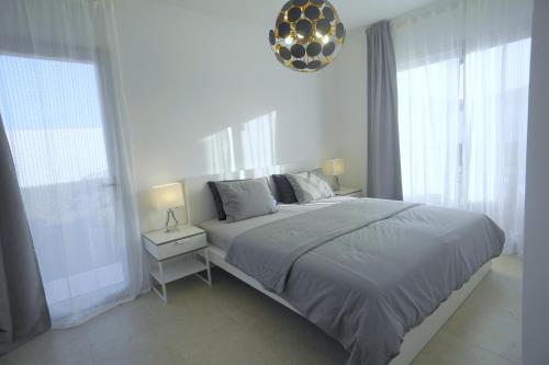 普拉亚布兰卡Villa Patricia Playa Blanca的白色卧室设有大床和窗户