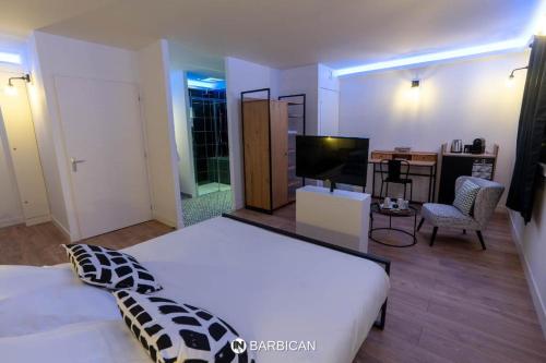 维拉尔雷东布Barbican的卧室配有一张白色大床和电视。