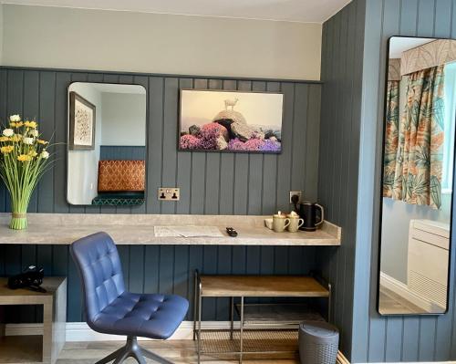 埃耶The White Horse Hotel and Luxury Shepherds Huts的蓝色的浴室设有梳妆台和蓝色椅子