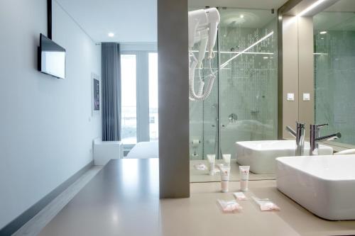 马亚Stay Hotel Porto Aeroporto的浴室配有白色水槽和淋浴。