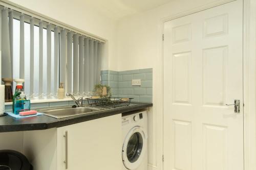 考文垂Eden House的厨房配有水槽和洗衣机