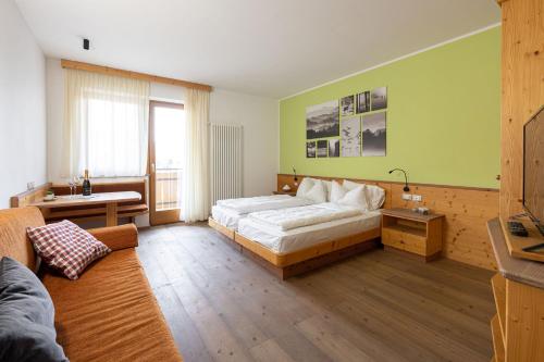 萨洛尔诺Grünwald的一间卧室配有一张床、一张桌子和一张沙发