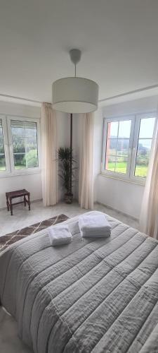LagoHostal Restaurante Os Faroles playa de Esteiro的白色的客房设有大窗户,配有一张大床。
