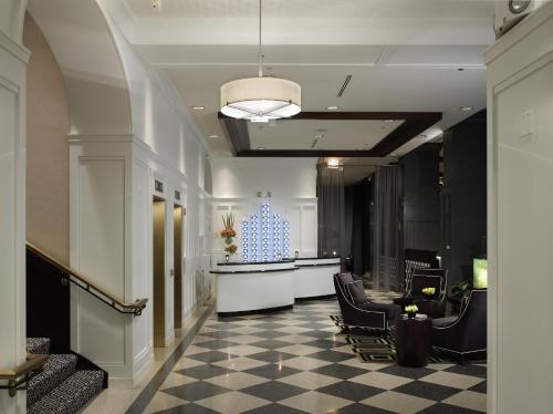 芝加哥芝加哥沃里克阿勒顿酒店的大堂设有配备椅子和柜台的等候室