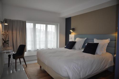 莱蓬德塞三地酒店的卧室设有一张白色大床和一扇窗户。